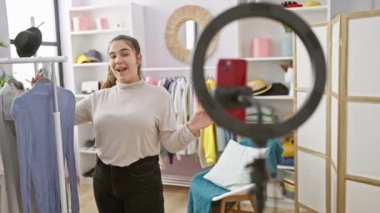 Genç bir İspanyol kadın, iç mekan giyinme odasında kıyafetlerini seçerken moda hakkında vloglar yapıyor, yaşam tarzını ve güzelliğini gösteriyor..