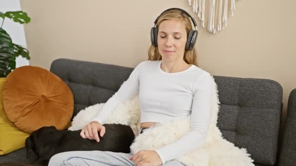 Uma Jovem Relaxada Gosta Música Fones Ouvido Enquanto Acaricia Labrador — Vídeo de Stock