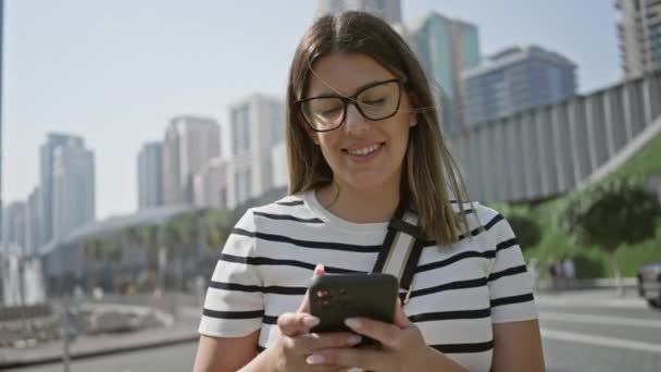 Uma Jovem Usa Smartphone Uma Rua Ensolarada Dubai Com Arranha — Vídeo de Stock