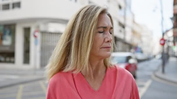 Reife Blonde Frau Pinkfarbener Bluse Steht Nachdenklich Auf Einer Städtischen — Stockvideo
