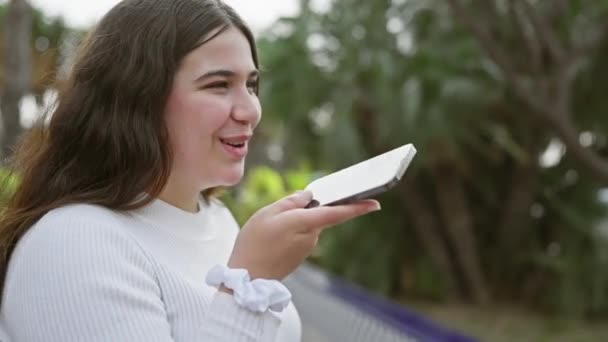Una Alegre Joven Hispana Usando Teléfono Inteligente Exuberante Entorno Parque — Vídeo de stock
