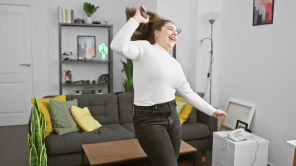 Glad Kvinna Dansar Ensam Ett Modernt Vardagsrum Uttrycker Lycka Och — Stockvideo