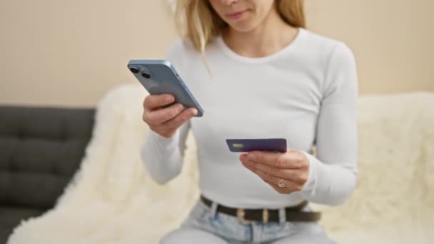 若い女性が屋内でスマートフォンを使用してクレジットカード情報をキャプチャし 現代の金融とセキュリティのコンセプトを反映 — ストック動画