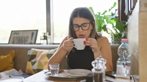 女人在咖啡桌边喝咖啡 在室内展示休闲时尚和休闲的生活方式 — 图库视频影像
