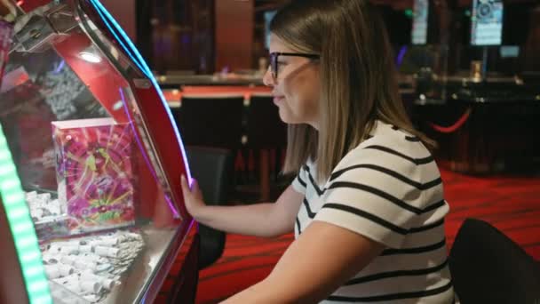 Μια Χαμογελαστή Γυναίκα Παίζει Ένα Παιχνίδι Arcade Καζίνο Αποπνέοντας Χαρά — Αρχείο Βίντεο