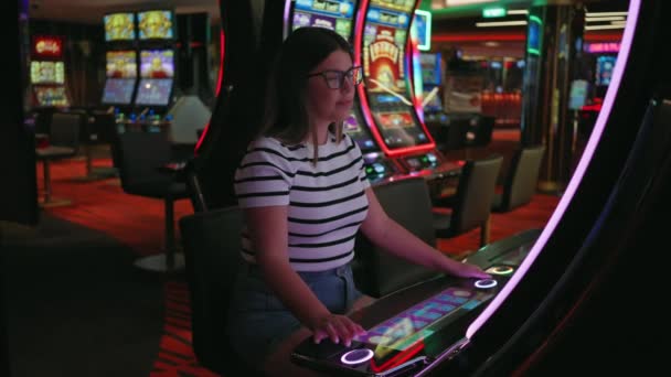 Una Joven Sonriente Juega Tragamonedas Electrónicas Casino Vibrante Exudando Emoción — Vídeo de stock