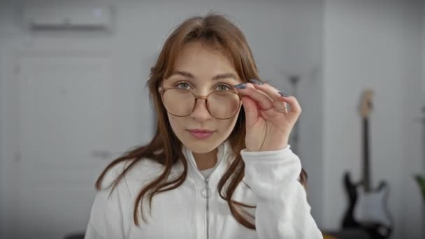 Gözlüklü Neşeli Genç Bir Kadın Rahat Bir Oturma Odasında Gülüyor — Stok video