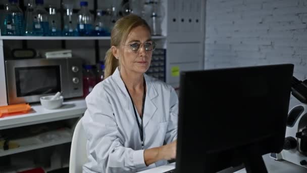 성숙한 과학자는 안경을 스트레칭 그녀의 실험실 스테이션에서 결과를 — 비디오