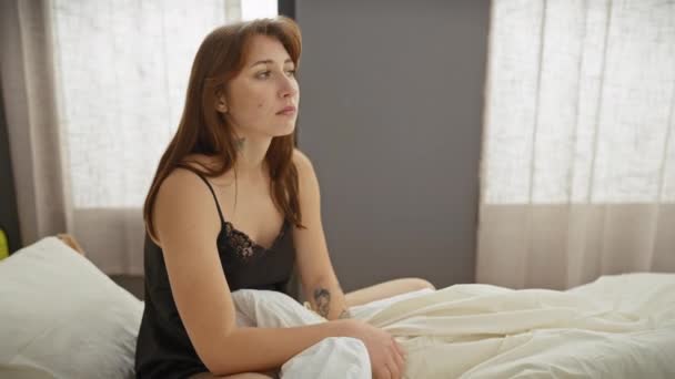 Zamyślona Młoda Kobieta Siedzi Sypialni Światło Słoneczne Przenika Przez Zasłony — Wideo stockowe
