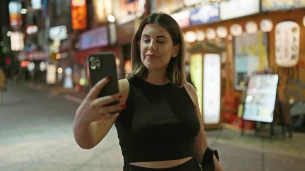 Selvsikker Vakker Hispanic Kvinne Smiler Tar Selfie Tokyo Street Nyter – stockvideo
