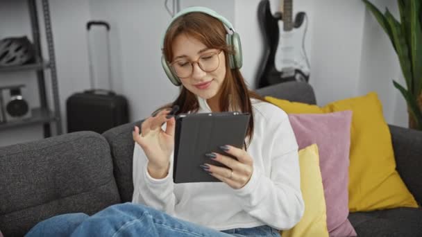 Młoda Kobieta Słuchawkach Korzysta Tabletu Przytulnym Salonie — Wideo stockowe
