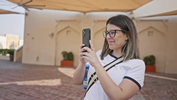 Een Lachende Vrouw Met Een Bril Gebruikt Een Smartphone Doha — Stockvideo