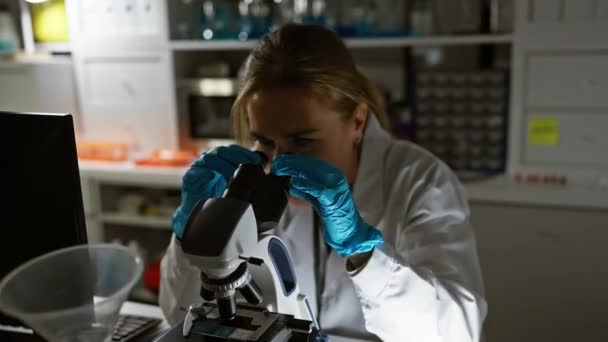 一位面带微笑的女科学家在实验室里用显微镜检查样品 — 图库视频影像