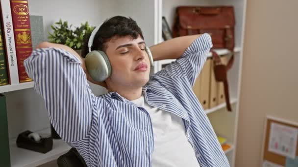Joven Relajado Con Auriculares Que Desenrolla Ambiente Acogedor Oficina Exhibiendo — Vídeos de Stock