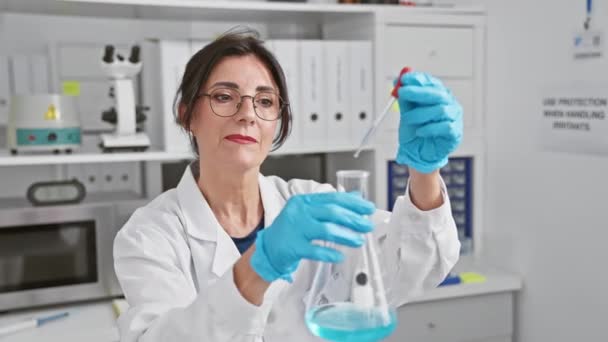 성숙한 히스패닉 과학자는 실험실 환경에서 피펫과 플라스크를 사용하여 실험을 — 비디오