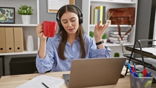 Zwykła Profesjonalna Latynoska Kobieta Słucha Muzyki Słuchawkami Przy Biurku Trzymając — Wideo stockowe