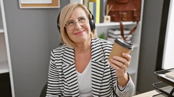 Усміхнена Блондинка Навушниках Тримає Каву Сучасному Офісі — стокове відео