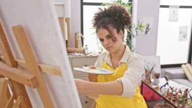 Öfkeli, kıvırcık saçlı kadın sanatçı stüdyoda oturup öfkesini ve öfkesini bağırarak haykırıyor.