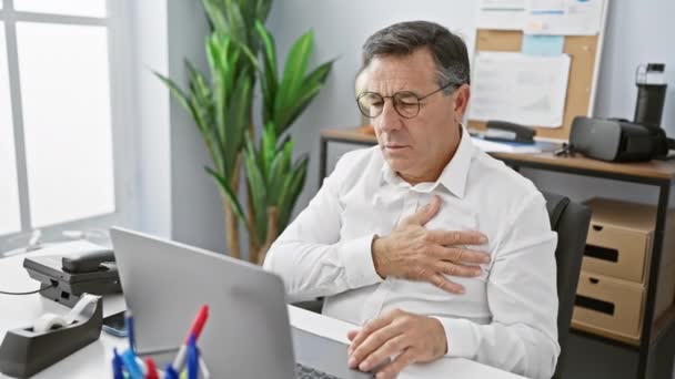一位中年商人在明亮的办公室里用笔记本电脑工作时胸部感到疼痛 — 图库视频影像