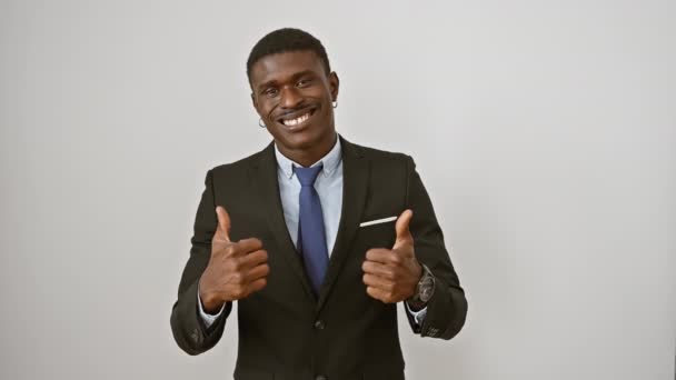 陽気なアフリカ系アメリカ人男性は 成功のために親指を振りかざし 白い背景に孤立しています 彼のポジティブな笑顔は勝者のバイブを発する — ストック動画
