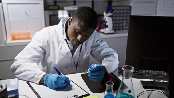 Afrikansk Manlig Forskare Antecknar Laboratoriemiljö Med Testutrustning Och Dator Bakgrunden — Stockvideo