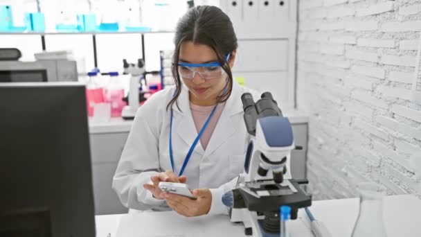 Ισπανίδα Επιστήμονας Γυναίκα Που Χρησιμοποιεί Smartphone Και Μικροσκόπιο Εργαστηριακό Περιβάλλον — Αρχείο Βίντεο