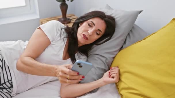 Uma Mulher Hispânica Madura Deitada Cama Interagindo Com Seu Smartphone — Vídeo de Stock