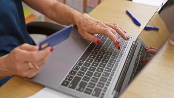 女性はオフィスで彼女のラップトップでオンラインショッピングを行い クレジットカードを持ち テクノロジーとEコマースを紹介しています — ストック動画