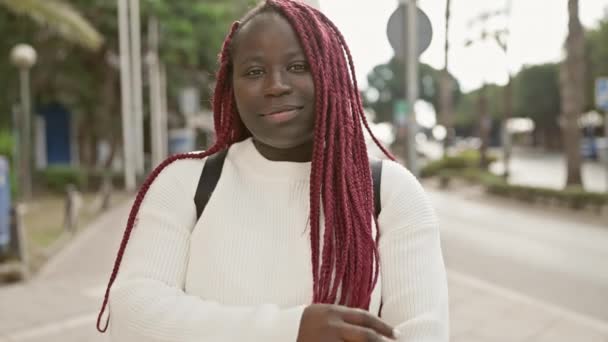 Pewna Siebie Afrykańska Kobieta Czerwonymi Warkoczami Miejskim Otoczeniu Uśmiechnięta Skrzyżowane — Wideo stockowe
