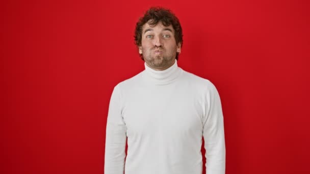 웃기는 얼굴을 만드는 건방진 히스패닉 빨간색 스웨터에 재미있는 빨간색 배경에 — 비디오