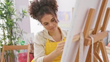 Kıvırcık saçlı, gülümseyen İspanyol sanatçı stüdyoda parmak ucuyla işaret ederek harika bir fikir ve iyi bir anı kutluyor.!