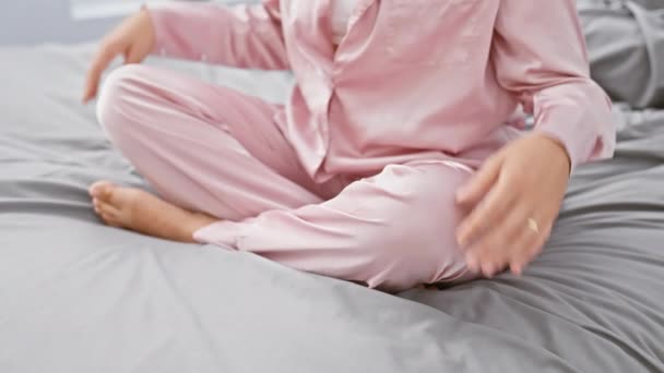 一个穿着粉色睡衣的宁静的女人在舒适的床上练习冥想 流露出平静和专注的神气 — 图库视频影像