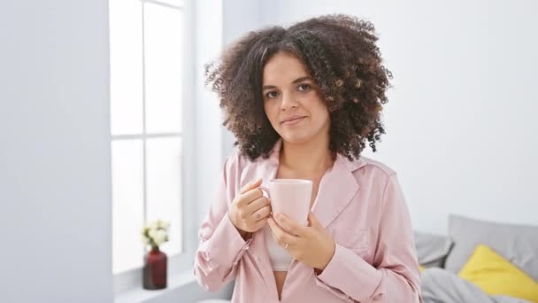 Uśmiechnięta Młoda Kobieta Kręconymi Włosami Delektująca Się Kawą Domu Przytulnym — Wideo stockowe