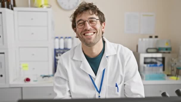 Jovem Cientista Hispânico Sorrindo Usando Óculos Jaleco Ambiente Laboratório Clínica — Vídeo de Stock