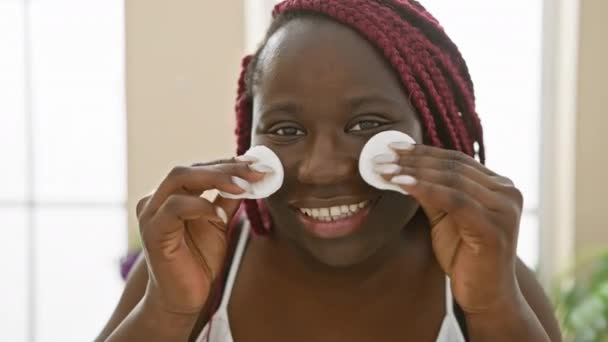 Sorrindo Afro Americana Com Tranças Usando Almofadas Algodão Seu Rosto — Vídeo de Stock