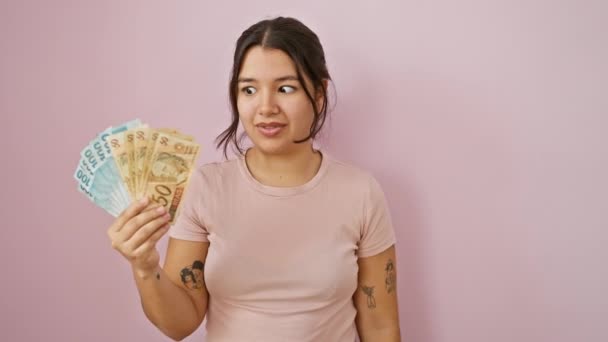 Шокированная Молодая Латиноамериканка Сжимает Бразильские Банкноты Пораженное Выражение Лица Розовом — стоковое видео