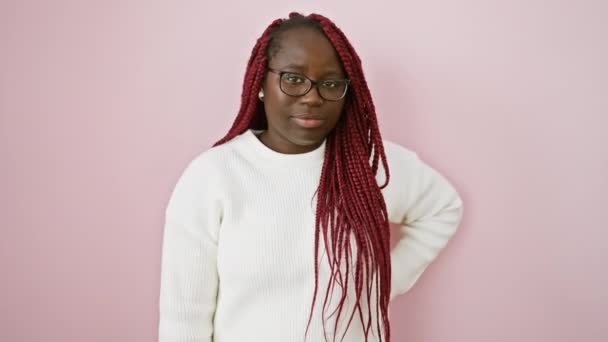 Una Mujer Afroamericana Con Trenzas Con Gafas Sobre Fondo Rosa — Vídeo de stock