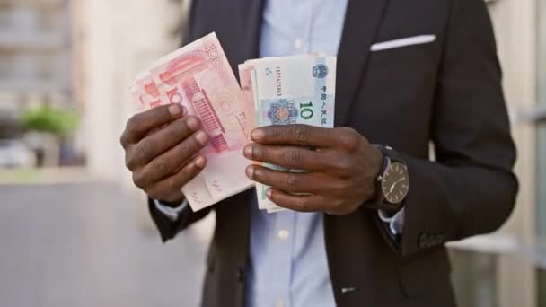 アフリカのビジネスマンが街頭で中国人民元を保持 — ストック動画