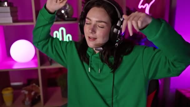 Joyful Young Woman Wearing Headphones Dances Neon Lit Gaming Room — Stock Video