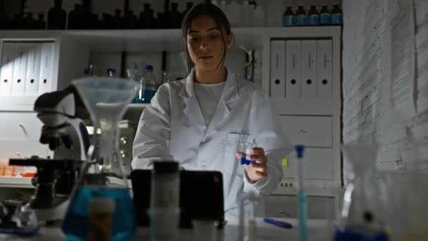 Científica Hispana Analizando Líquido Azul Frasco Laboratorio Investigación — Vídeos de Stock