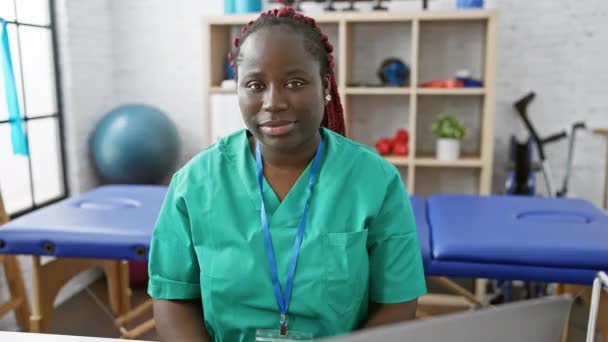 Веселая Африканка Халате Показывает Сердечный Жест Интерьере Реабилитационной Клиники — стоковое видео