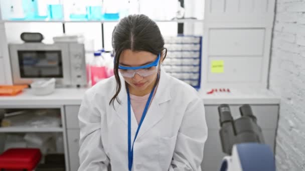 这位年轻 惊慌失措的女科学家站在她信任的实验室里 戴着安全眼镜 严肃而自然地看着镜头 紧紧地盯着自己的肖像 — 图库视频影像