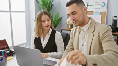 Erkek ve kadın modern bir ofiste çalışırken erkek hapşırıyor.