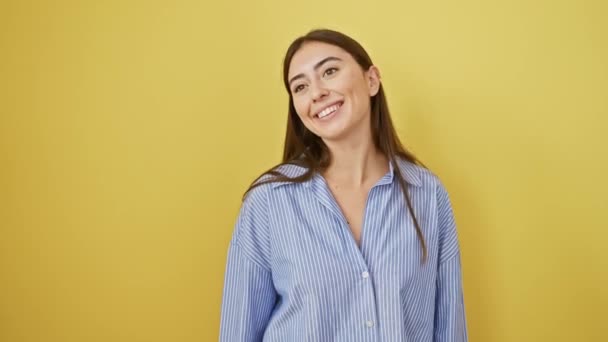 シャツを着た若いヒスパニックの女性は 幸せに自然な表情で笑い 離れて見て 孤立した黄色の背景の側面のプロフィール — ストック動画