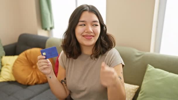 Fiatal Gyönyörű Spanyol Kanapén Kezében Hitelkártya Mutatva Hüvelykujját Oldalán Mosolyogva — Stock videók