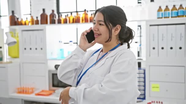 Uma Mulher Hispânica Sorridente Casaco Laboratório Fala Telefone Uma Farmácia — Vídeo de Stock
