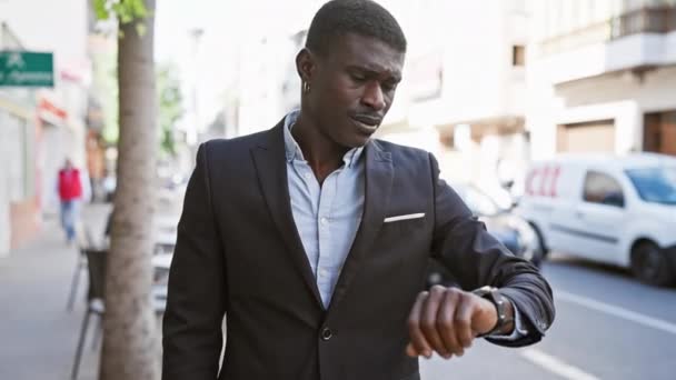 Stylový Africký Muž Obleku Kontroluje Čas Svých Hodinkách Slunné Ulici — Stock video