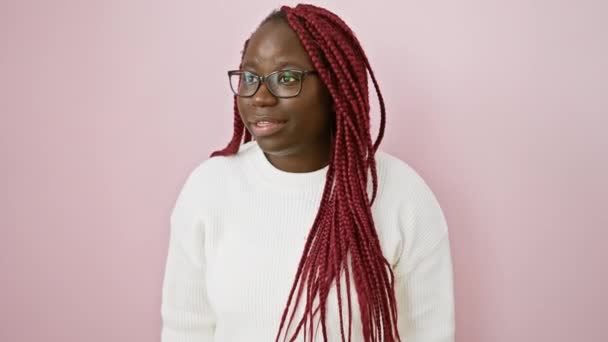 Glædelig Afrikansk Kvinde Med Fletninger Briller Udgør Mod Lyserød Baggrund – Stock-video