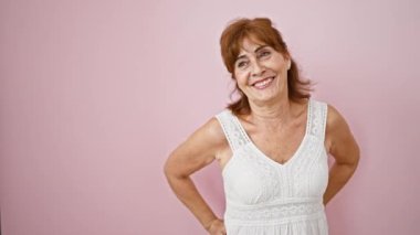 Kendinden emin orta yaşlı bir kadın, doğal güzelliğiyle hava atıyor, moda elbisesiyle gülüp geçiyor. Güzel kızıl saçlılar saf mutlulukla gülümsüyor, yanlamasına pembe arka planda duruyorlar..