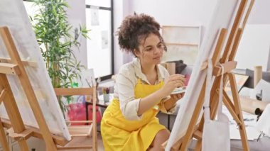 Kıvırcık saçlı, arkadaş canlısı İspanyol sanatçı stüdyoda başarılı bir tokalaşma teklif ediyor, hoş bir gülümseme yayıyor, iş anlaşmalarını mühürlüyor, güveni vurguluyor..